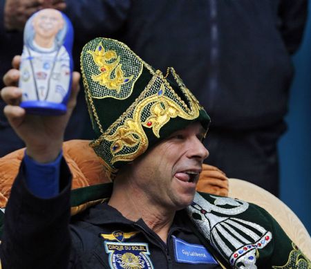 Canadian circus billionaire Guy Laliberte, in a Kazakh national costume, smiles as he holds up a Russian matryoshka doll at a news conference at Kustanai airport, October 11, 2009, before his departure to Moscow. Laliberte returned from the International Space Station (ISS) after staying about two weeks in space.[Xinhua/Reuters]