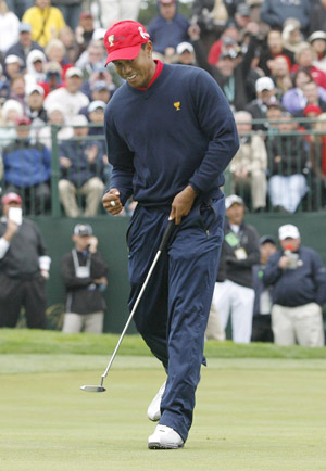 U.S. team member Tiger Woods pumps his fist after making a birdie putt to win the ninth hole during his singles match at the Presidents Cup golf tournament at Harding Park golf course in San Francisco, California, October 11, 2009. [Xinhua/Reuters]