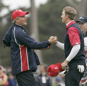 U.S. team captain Fred Couples (L) shakes hands with Hunter Mahan after Mahan won his singles match on the 17th hole at the Presidents Cup golf tournament at Harding Park Golf Course in San Francisco, California October 11, 2009. [Xinhua/Reuters]