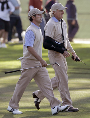 International team captain Greg Norman (R) of Australia walks the 18th fairway with Mike Weir of Canada during their fourball match at the Presidents Cup golf tournament at Harding Park Golf Course in San Francisco, California October 9, 2009. [Xinhua/Reuters]