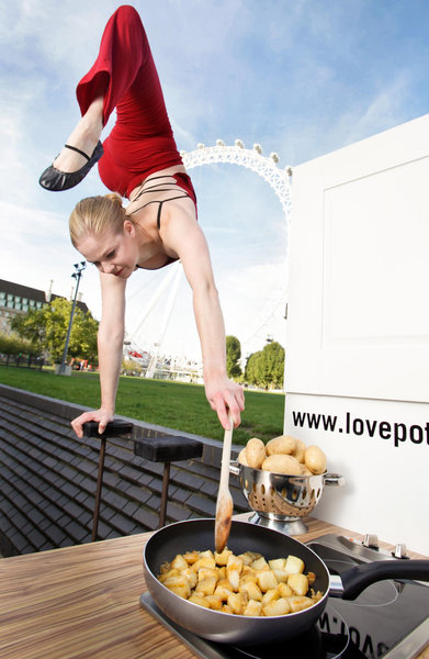 Acrobat Tina Tuomisto demonstrates how easy it is to cook potatoes in central London by cooking Castilian potatoes while standing on one hand for the launch of the Potato Council's Love Potatoes campaign. [CFP]