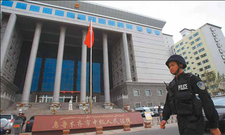 A police officer patrols outside the Intermediate People's Court of Urumqi in the capital of the Xinjiang Uygur autonomous region yesterday as the court handed down death sentences to six people convicted of murder in the July 5 riots. CNS