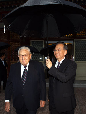 Chinese Premier Wen Jiabao (R) holds an umbrella for former U.S. Secretary of State Henry Kissinger against the rain to see him off after a meeting in Beijing, capital of China, Oct. 12, 2009. Kissinger and his delegation came to Beijing for the inaugural China-U.S. Track Two High-Level Dialogue, which gathered dozens of retired eminent diplomats and officials from both countries. [Yao Dawei/Xinhua] 