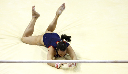 England's gymnast Beth Tweddle loses her grip at the uneven bars and falls, a day before the start of the World Gymnastic Championships, at the O2 Arena in London October 12, 2009. [Xinhua/Reuters]