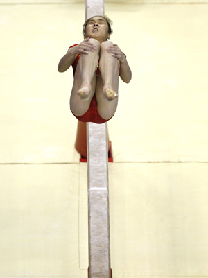 A gymnast practices her routine on the beam a day before the start of the World Gymnastic Championships at the O2 Arena in London October 12, 2009. [Xinhua/Reuters]