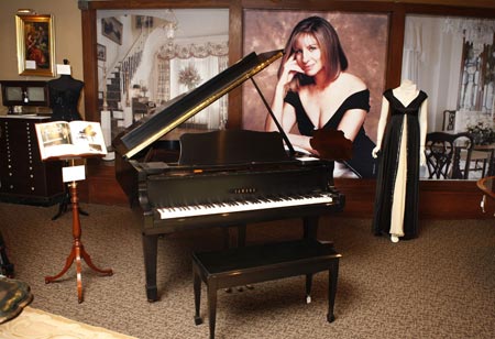 A Yamaha Baby Grand Piano (C) estimated to bring $10,000 and Barbra Streisand's concert gown worn during her 1993-95 tour valued at $5,000 are shown at a press preview of items from the auction 'The Collection of Barbra Streisand' in Beverly Hills October 12, 2009. [Xinhua/Reuters]