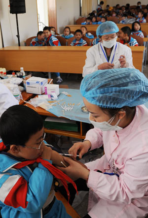 A pupil is injected the vaccine against the A/H1N1 flu in Lhasa, capital of southwest China's Tibet Autonomous Region, Oct. 14, 2009. [Gesang Dawa/Xinhua] 