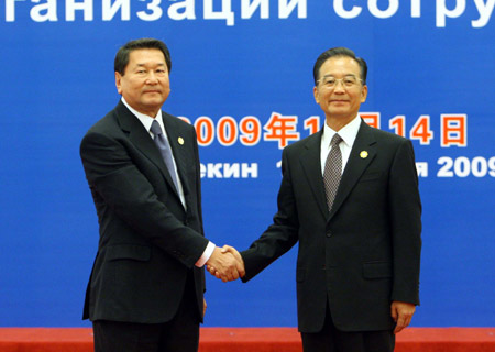 Premier Wen Jiabao (R) shakes hands with the Shanghai Cooperation Organization (SCO) Secretary-General Bolat Nurgaliyev prior to the eighth prime ministers' meeting of the Shanghai Cooperation Organization member states at the Great Hall of the People in Beijing, capital of China, Oct. 14, 2009. (Xinhua/Liu Weibing)