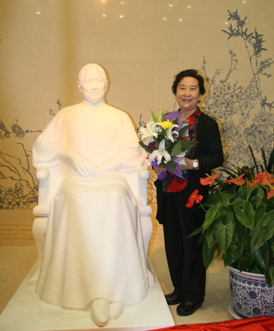 Sculptor Zhang Dedi poses next to her latest Soong Ching Ling statue in the exhibition hall in Soong's former residence in Beijing.