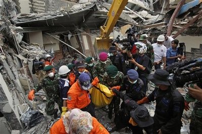 Indonesian rescue workers remove a body from the Amberchang Hotel which collapsed in Wednesday's earthquake, in the Sumatran Island city of Padang, Indonesia, Saturday, Oct. 3, 2009. [China Daily via Agencies]