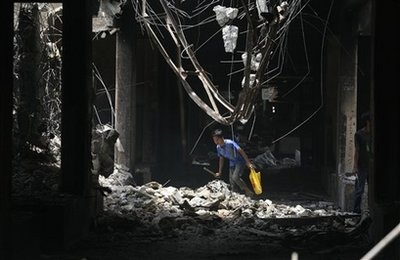 A boy crawls under overhanging rocks from what used to be a market on Sunday Oct. 4, 2009 in Padang, Indonesia.[Agencies]