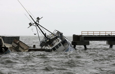 A half sunken fishing boat floats next to a broken dock after Hurricane Jimena hit Puerto San Carlos in Mexico's state of Baja California September 2, 2009.[Agencies]