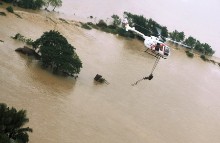 A resident is rescued by helicopter in Carmen, Pangasinan, northern Philippines in this photo released by the Philippine Coast Guard October 9, 2009.[Agencies]