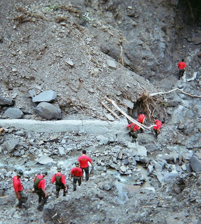 Soldiers climb over a road destroyed by a landslide, following Typhoon Morakot, near Liugui, Pingtung County in southern Taiwan August 24, 2009.[Agencies]