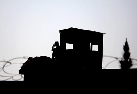 An Afghan soldier sits guard during a ceremony commemorating dead Afghan armed force in Kabul, capital of Afghanistan, Oct. 14, 2009. [Zabi Tamanna/Xinhua]