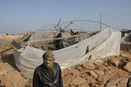 A Palestinian man inspects the entrance to a smuggling tunnel following an Israeli airstrike in Rafah near the border between Egypt and the southern Gaza Strip on October 14, 2009. An early morning Israeli air raid on smuggling tunnels between Gaza and Egypt killed a 23-year-old Palestinian man and wounded four other people, Palestinian medics said. [Khaled Omar/Xinhua]