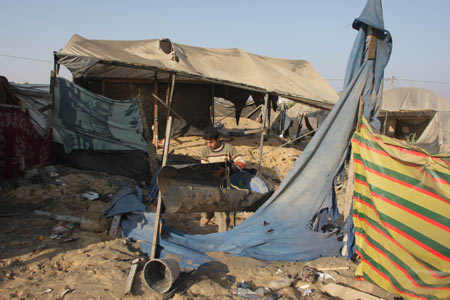 A Palestinian man inspects the entrance to a smuggling tunnel following an Israeli airstrike in Rafah near the border between Egypt and the southern Gaza Strip on October 14, 2009. [Khaled Omar/Xinhua]