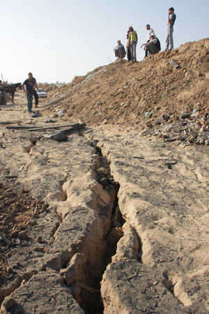 Palestinians inspect the entrance to a smuggling tunnel following an Israeli airstrike in Rafah near the border between Egypt and the southern Gaza Strip on October 14, 2009. [Khaled Omar/Xinhua]