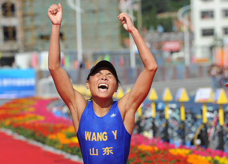 Wang Yi from Shandong Province jubilates after 10-kilometer run in the women's triathlon at the China's 11th National Games in Weihai City, east China's Shandong Province, Oct. 14, 2009. Wang Yi claimed the title with 2:16:02.77. [Li Gang/Xinhua]