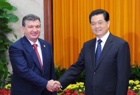 Chinese President Hu Jintao (R) shakes hands with Uzbek Prime Minister Shavkat Mirziyaev at the Great Hall of the People in Beijing, capital of China, Oct. 14, 2009. [Fan Rujun/Xinhua]