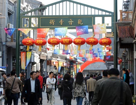 Pedestrians walk on the Dashila West Street in Beijing, capital of China, on Oct. 15, 2009. The Dashila West Street used to be called Guanyinsi Street in the old times. The 323-meter long street, which reopened on Thursday, is one of the most historic featured streets in Beijing. [Zhang Xu/Xinhua]