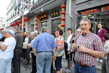 Foreigners walk on the Dashila West Street in Beijing, capital of China, on Oct. 15, 2009. The Dashila West Street used to be called Guanyinsi Street in old times. The 323-meter long street, which reopened on Thursday, is one of the most historic featured streets in Beijing. [Zhang Xu/Xinhua]