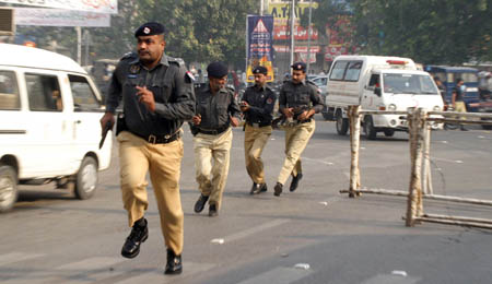 Pakistani policemen run to take position outside the Federal Investigation Agency (FIA), a police building after gunmen attacked in Lahore. Police said the attack at the FIA building was quickly repelled and that firing had stopped at Manawan, where police reinforcements were inside. [AFP/Xinhua] 