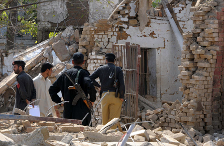 Pakistani policemen inspect a damaged police station following a suicide car blast in the northwestern town of Kohat. Militants have unleashed coordinated attacks on Pakistani police in which 27 people died, storming offices in Lahore and bombing a northwest station to escalate 11 days of carnage.[AFP/Xinhua] 