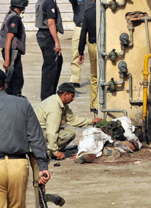 A Pakistani bomb disposal squad member removes a suicide jacket from the body of an attacker at the premises of Federal Investigation Agency (FIA), a criminal police building after gunmen attacked in Lahore. [AFP/Xinhua] 