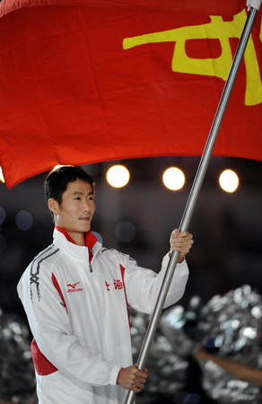 Wang Liqin, a renowned Pingpong player, marches on as the flagman of the delegation of Shanghai at the opening ceremony of the 11th National Games held in Jinan, Shandong Province Oct 16, 2009. [Xinhua]