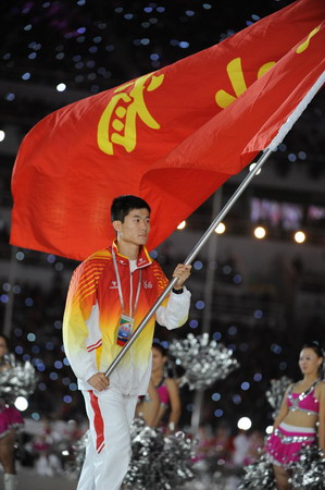 Shi Dongpeng, a renowned hurdler, marches on as the flagman of the delegation of Hebei Province at the opening ceremony of the 11th National Games held in Jinan, Shandong Province Oct 16, 2009. [Xinhua]