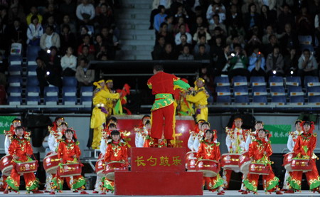 Folk artists perform the drum dance before the opening ceremony of the 11th National Games held in Jinan, Shandong Province Oct 16, 2009. [Xinhua]