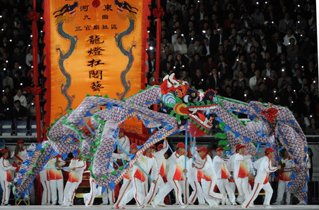Folk artists perform the dragon dance before the opening ceremony of the 11th National Games held in Jinan, Shandong Province Oct 16, 2009. [Xinhua]