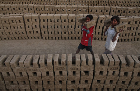 Indian migrant child laborers work at a brick kiln in Brakpora Anantnag, some 65 kilometers south of Srinagar, summer capital of Indian controlled Kashmir, Oct. 16, 2009. [Javed Dar/Xinhua Photo]