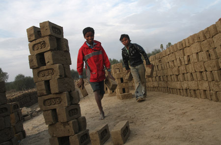 Indian migrant child laborers work at a brick kiln in Brakpora Anantnag, some 65 kilometers south of Srinagar, summer capital of Indian controlled Kashmir, Oct. 16, 2009. [Javed Dar/Xinhua Photo]