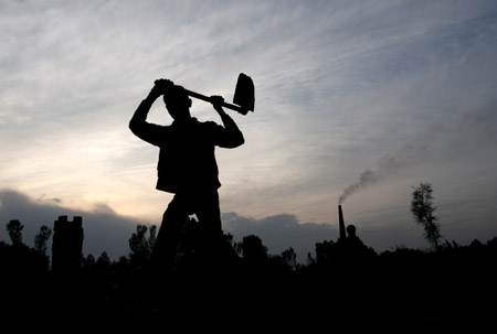 An Indian migrant child laborer works at a brick kiln in Brakpora Anantnag, some 65 kilometers south of Srinagar, summer capital of Indian controlled Kashmir, Oct. 16, 2009. [Javed Dar/Xinhua Photo]