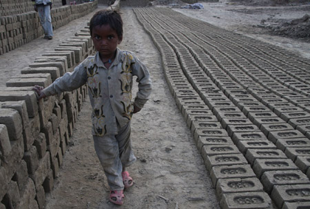 An Indian migrant child laborer takes a rest at a brick kiln in Brakpora Anantnag, some 65 kilometers south of Srinagar, summer capital of Indian controlled Kashmir, Oct. 16, 2009. [Javed Dar/Xinhua Photo]