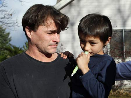  Richard Heene (L) reacts as he holds his son six-year-old Falcon Heene outside their house in Fort Collins, Colorado Oct. 15, 2009. [Xinhua/Reuters]