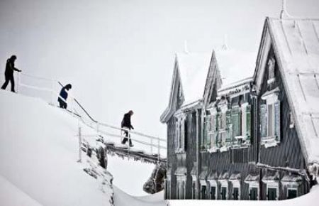 People head towards a restaurant covered with ice and snow on the Saentis mountain in Switzerland.[CCTV]