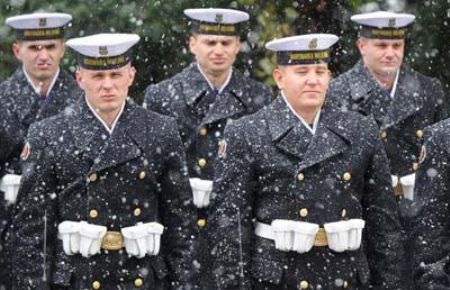 Polish Army soldiers stand in falling snow as they wait for a military ceremony in Warsaw.[CCTV]