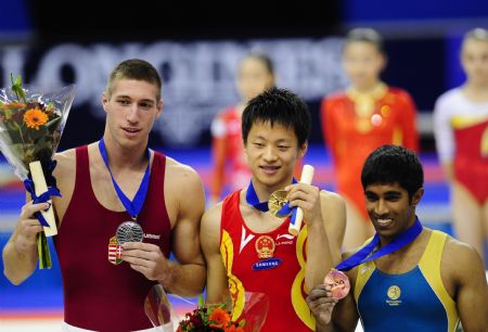 Gold medalist Zhang Hongtao (C) of China, silver medalist Krisztian Berki of Hungary (L) and bronze medalist Sellathurai P. of Australia pose during the victory ceremony of the Pommel Horse final of the 41st Artistic Gymnastics World Championships in London, Britain, Oct. 17, 2009. (Xinhua/Zeng Yi) 