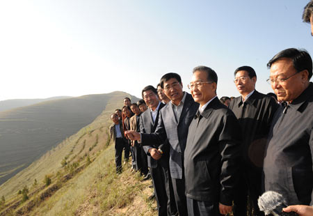 Chinese Premier Wen Jiabao (2nd R Front) visits Zhaojiapu Village in Chankou Township of Dingxi City, northwest China's Gansu Province, Oct. 17, 2009. He has urged the once impoverished northwestern Gansu Province to continue developing industries with local features while ensuring the safety of local ecological system. Premier Wen made an inspection tour in Gansu from Oct. 17 to 18. [Li Xueren/Xinhua]