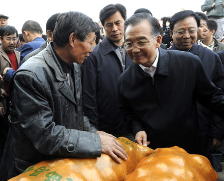 Chinese Premier Wen Jiabao (R Front) listens to a dealer at the Dingxi potato trading center in Dingxi City, northwest China's Gansu Province, Oct. 17, 2009. Premier Wen made an inspection tour in Gansu from Oct. 17 to 18. [Li Xueren/Xinhua]