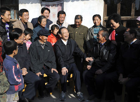 Chinese Premier Wen Jiabao (3rd R Front) smiles while chatting with Jia Xin (2nd R Front) and other residents at Zhaojiapu Village in Chankou Township of Dingxi City, northwest China's Gansu Province, Oct. 17, 2009. Premier Wen made an inspection tour in Gansu from Oct. 17 to 18. [Li Xueren/Xinhua]