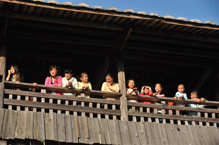 Local villagers enjoy sunshine on a roofed wooden arch bridge-- Wan'an Bridge in Pingnan County of southeast China's Fujian Province, Oct. 17, 2009. [Jiang Kehong/Xinhua]