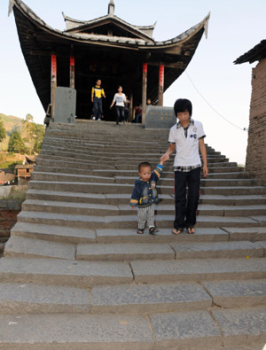 Local people walk on Wan'an Bridge, a roofed wooden arch birdge, in Pingnan County of southeast China's Fujian Province, Oct. 17, 2009. [Jiang Kehong/Xinhua]