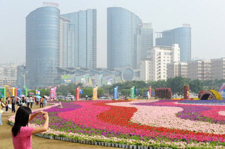  Visitors take photos near the main exhibition hall of the 2009 China-ASEAN Expo (CAEXPO) at the Nanning International Convention and Exhibition Center in Nanning, capital of southwest China's Guangxi Zhuang Autonomous Region, on Oct.19, 2009. [Ma Ping/Xinhua]