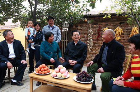 Chinese President Hu Jintao (3rd R), who is also general secretary of the Central Committee of the Communist Party of China and chairman of the Central Military Commission, talks with local cadres and residents in Dawang Township, Guangrao County, Dongying City, east China's Shandong Province, Oct. 18, 2009. [Ju Peng/Xinhua]