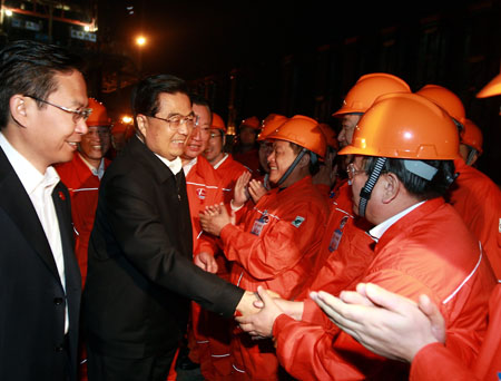 Chinese President Hu Jintao (2nd L, front), who is also general secretary of the Central Committee of the Communist Party of China and chairman of the Central Military Commission, talks to staff members of Shengli oil field, in east China's Shandong Province, Oct. 18, 2009. [Ju Peng/Xinhua]