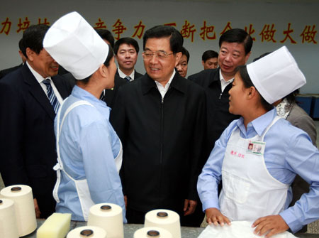 Chinese President Hu Jintao (C), who is also general secretary of the Central Committee of the Communist Party of China and chairman of the Central Military Commission, talks with workers at Shandong Weiqiao Textile Company in east China's Shandong Province, Oct. 17, 2009. [Ju Peng/Xinhua] 